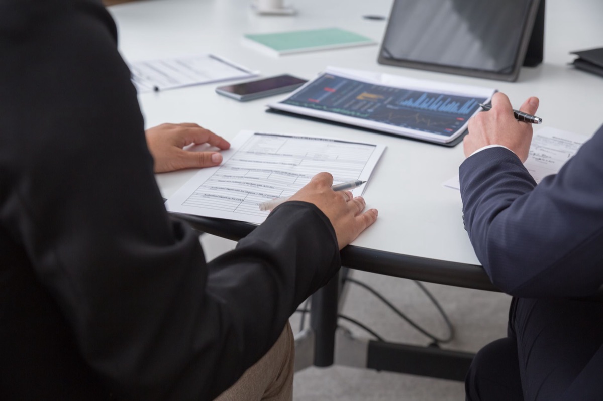 Government officials reviewing supply chain documents in a secure office setting